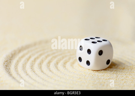 Art composition from playing dice on a sand surface Stock Photo
