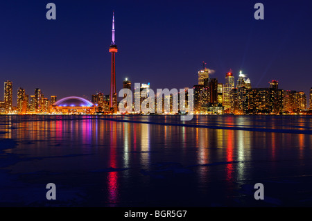 Toronto city skyline lights at night reflected on the frozen ice covered Lake Ontario in winter Stock Photo