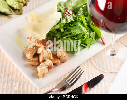 Salad with porcini mushrooms and arugula on a white plate Stock Photo