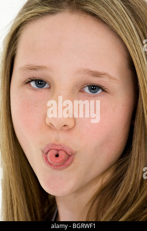 Caucasian preteen girl displaying some attitude by sticking out her tongue Stock Photo