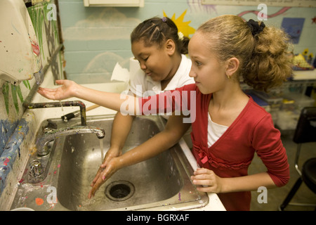 Girls wash up after an art class at an after school program at a community center in New York City. Stock Photo