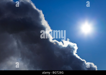 Photograph showing the sun and blue sky emerging from behind a storm cloud. Stock Photo
