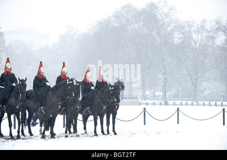 The Queen's Blues and Royals cavalry regiment on horses in the snow, London, England Stock Photo