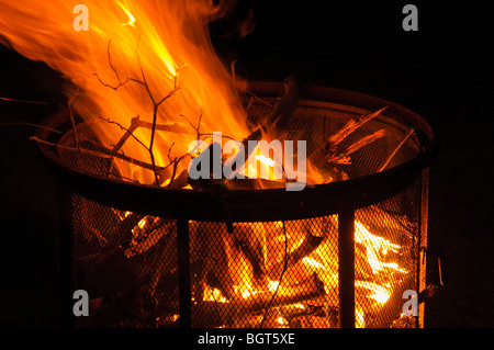 Evening camp fire in a free standing fire pit. Stock Photo