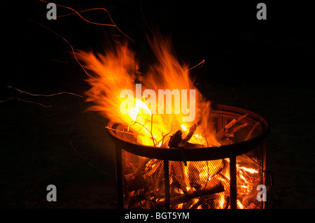 Evening camp fire in a free standing fire pit. Stock Photo