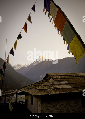 Prayer flags an house in Chomrong, Annapurna region, Nepal. Photo taken while trekking to Annapurna Base Camp. Stock Photo