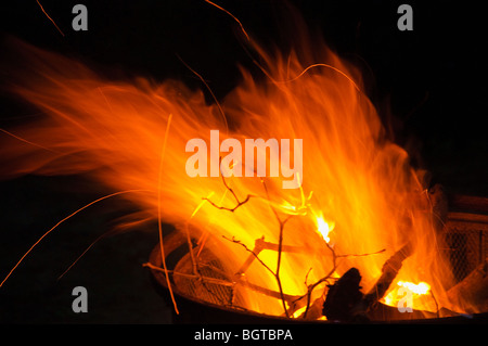 Evening camp fire in a free standing fire pit. Stock Photo