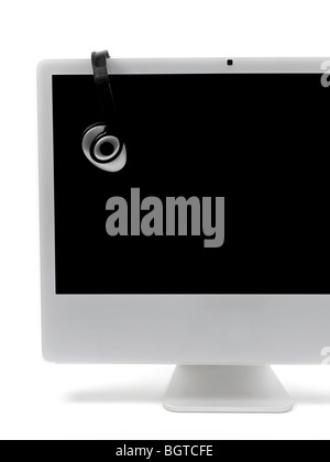 A desktop computer with a set of headphones isolated against a white background Stock Photo