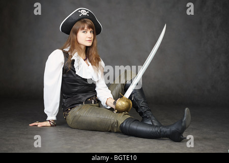 The young beautiful woman in clothes of the pirate with a sabre Stock Photo