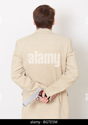 The person hides behind the back the weapon - the rear view Stock Photo