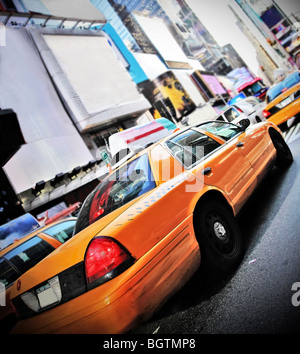 Yellow Cab in high contrast color and vignette speeding through Times Square New York Stock Photo