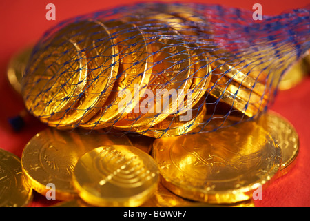 Chocolate gold coins on red background Stock Photo