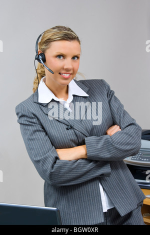 Caucasian businesswoman / secretary in her early 30s talking on a headset Stock Photo