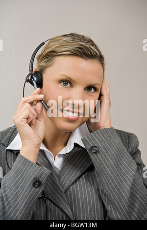 Caucasian businesswoman / secretary in her early 30s talking on a headset Stock Photo