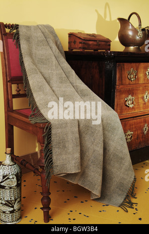 Ornamental antique furniture and a woven throw Stock Photo
