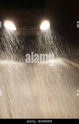 traffic in heavy snowfall; car driving on a snow covered road surface Stock Photo