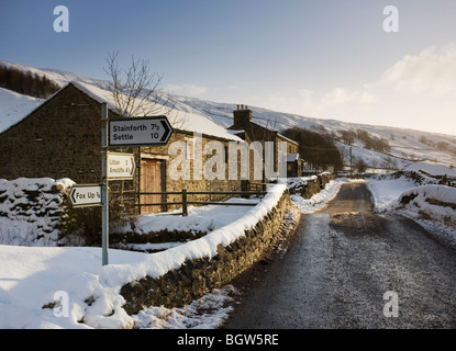 Country road Junction and Settle Stainforth road sign after heavy snowfall Winter 2009 09 Littondale Yorkshire Dales UK Stock Photo