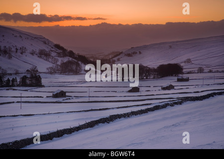 Sunrise over typical snow covered Yorkshire Dales scenery with Drystone Walls and Barns at Littondale, North Yorkshire, UK