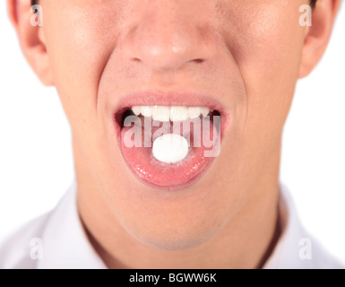 A young man taking a pill. All isolated on white background Stock Photo