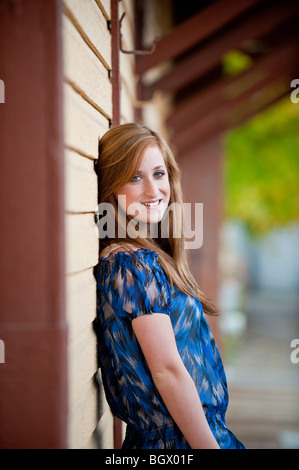 Pretty redheaded teen girl leaning against a wall Stock Photo