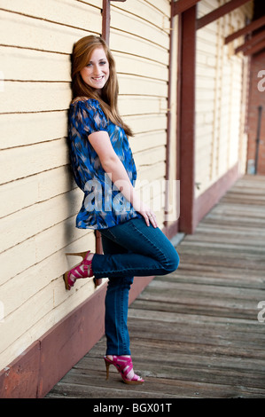 Pretty redheaded teen girl leaning against a wall Stock Photo
