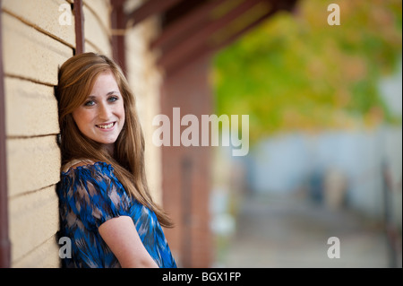 Pretty redheaded teen girl leaning against a wall Stock Photo