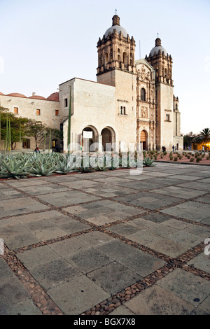important Baroque style Church of Santo Domingo at twilight with large plaza & agave cactus in foreground Oaxaca City Mexico Stock Photo