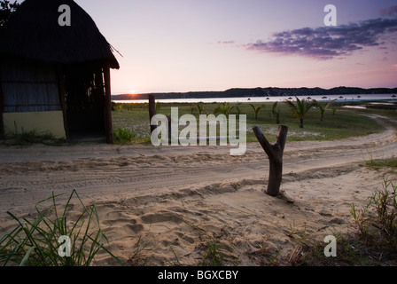 The sun rises behind a hut on the coast of Beline, Mozambique Stock Photo