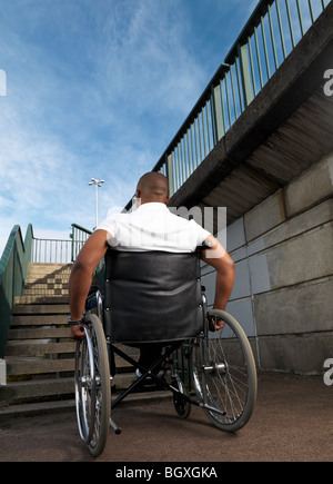 man in wheelchair in front of steps Stock Photo