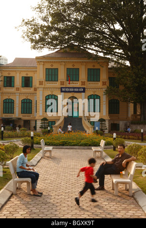 Vietnamese family relax in front of old french colonial building - Hanoi,Vietnam Stock Photo