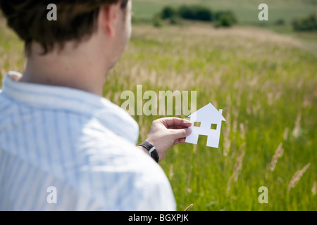 Hands holding cut-out paper houses Stock Photo