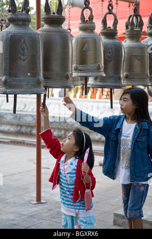 Thai girls ringing the bells. Wat Phanan Choeng. Ayutthaya. Thailand Stock Photo