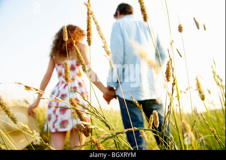 Couple holding hands in a wheat field Stock Photo