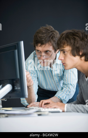 Student and teacher using computer together Stock Photo