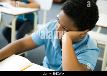 Male elementary school student bored in class Stock Photo