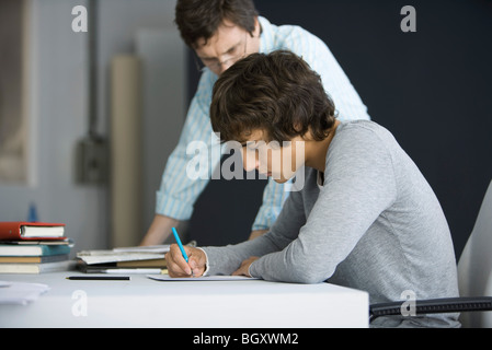 Male college student working with teacher's assistance Stock Photo