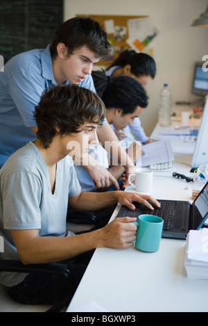 Male college students working together using laptop computer Stock Photo
