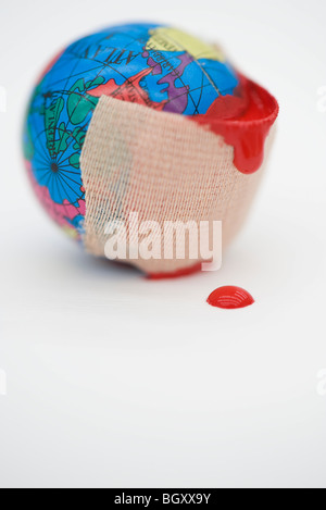 Adhesive bandage dripping blood wrapped around globe Stock Photo