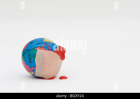 Adhesive bandage dripping blood wrapped around globe Stock Photo