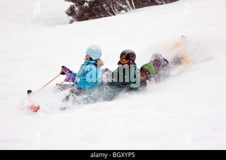 Children sledding in a fresh snowfall. Stock Photo