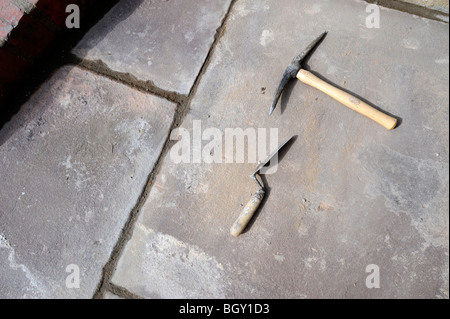 Builders tools on natural stone slabs recently laid to make a patio UK Stock Photo