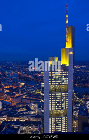 Commerzbank Tower illuminated with yellow lights at dusk as seen from the Main Tower in the City of Frankfurt am Main, Hessen, G Stock Photo