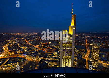 Commerzbank Tower illuminated with yellow lights at dusk as seen from the Main Tower in the City of Frankfurt am Main, Hessen, G Stock Photo