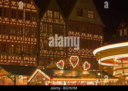 Lights from the market stalls and merry-go-round during the Christmas Markets at the Römerberg (City Hall Square) in the City of Stock Photo