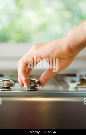 Hand adjusting stove knob Stock Photo