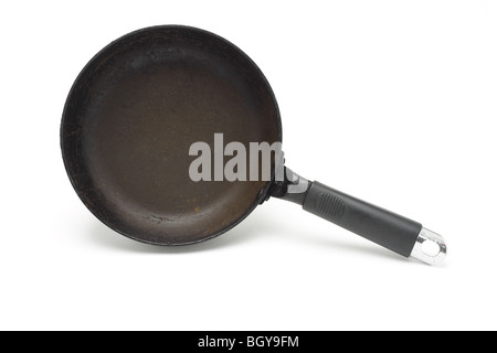 Old rusty frying pan standing on the side on white background Stock Photo