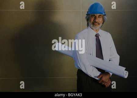 Architect carrying blueprint under arm, portrait Stock Photo