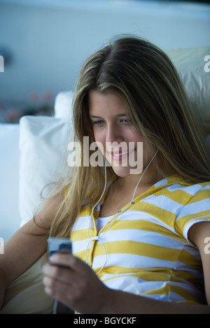 Young woman listening to MP3 player