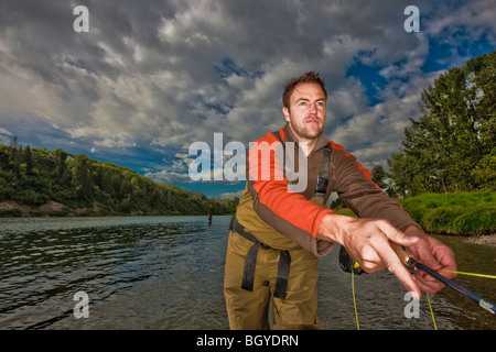 Fly-fisherman waiting with fishing pole on shoulder Stock Photo