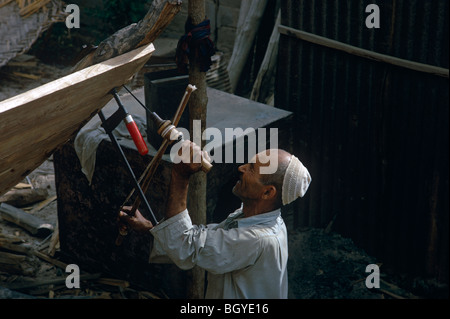 Traditional boat builder drilling with old-fashioned tools 